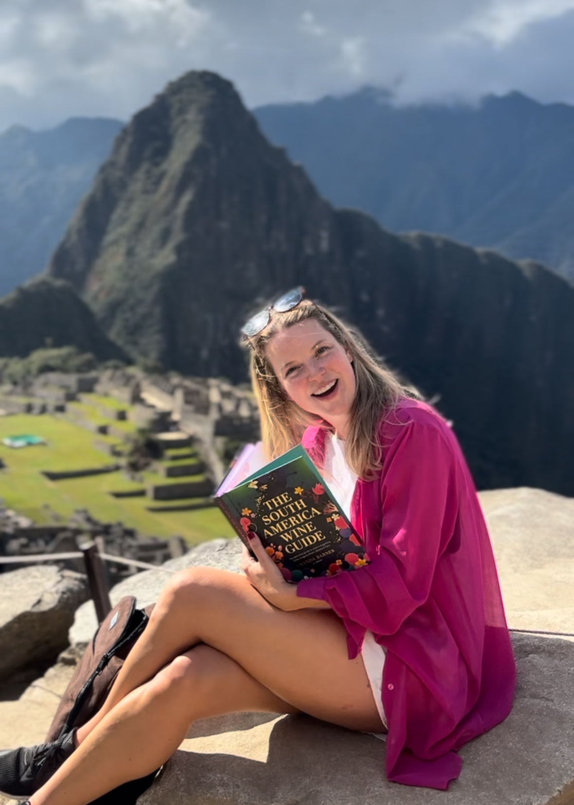 Amanda Barnes MW at Machu Picchu, holding The South America Wine Guide